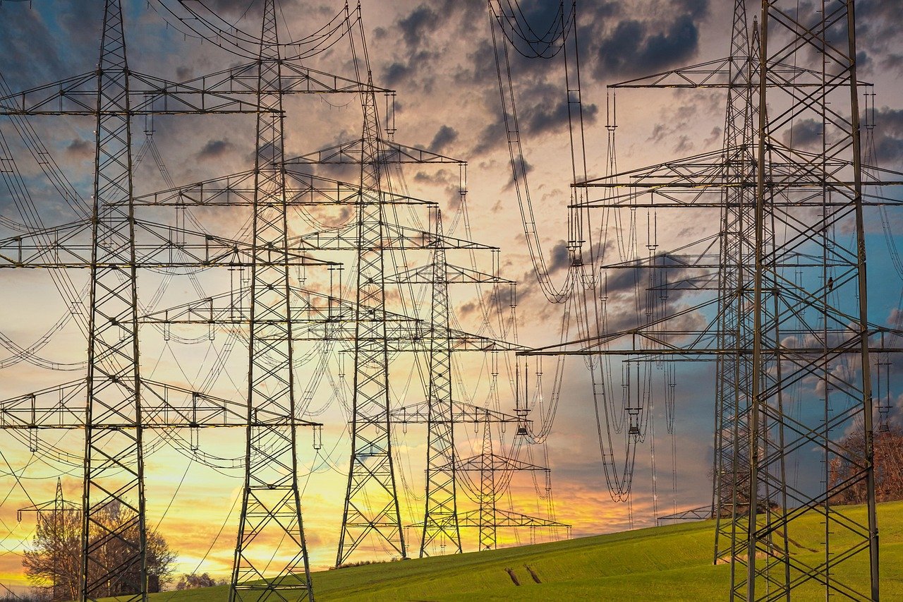 Rows of electricity pylons carrying power across a landscape